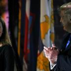 Amy Coney Barrett smiles at Donald Trump, who applauds her.